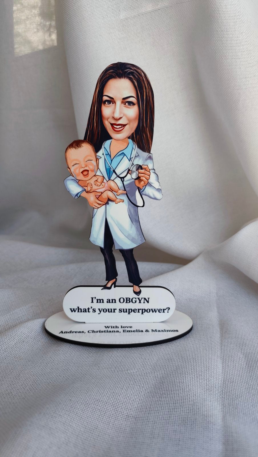 Caricature of a doctor holding a baby with a sign below on a white background